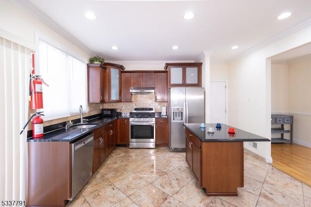 kitchen with a kitchen island, tasteful backsplash, sink, stainless steel appliances, and crown molding