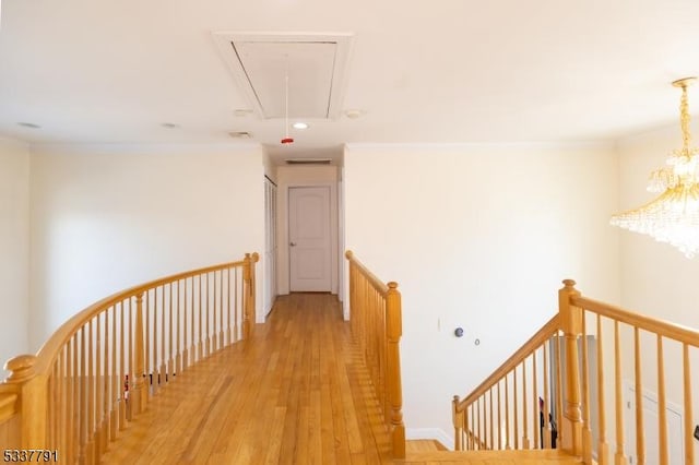 hall featuring ornamental molding, a chandelier, and light hardwood / wood-style flooring