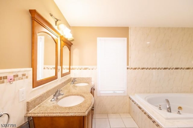 bathroom featuring tile patterned floors, tiled tub, tile walls, and vanity