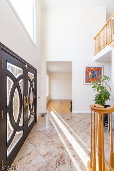 foyer featuring a high ceiling, ornamental molding, and french doors