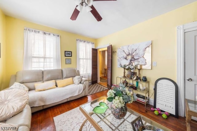 living room featuring dark wood-type flooring and ceiling fan