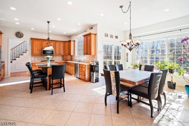 dining area featuring sink, a notable chandelier, and light tile patterned floors