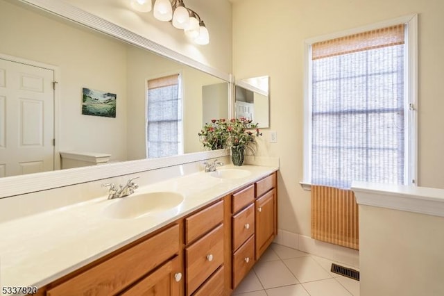 bathroom featuring a healthy amount of sunlight, toilet, tile patterned flooring, and vanity