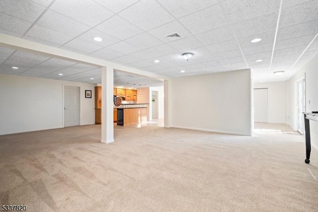 basement featuring light colored carpet and a drop ceiling