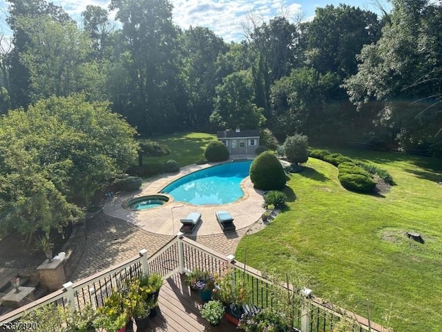 view of swimming pool with an in ground hot tub, a yard, and an outbuilding