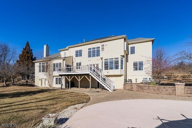 rear view of house with a deck and a lawn