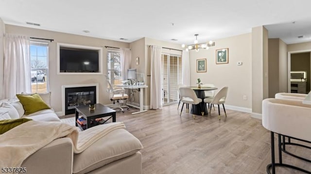 living room featuring a chandelier and light hardwood / wood-style floors