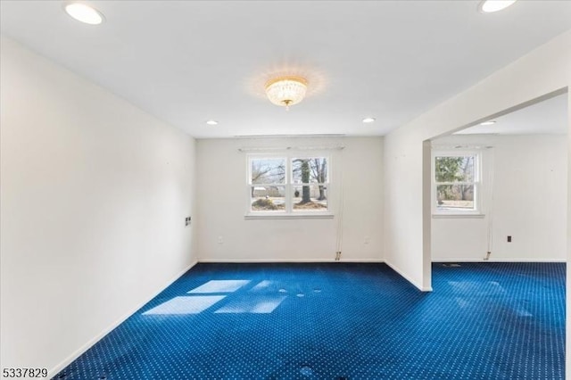 unfurnished room featuring baseboards, dark carpet, and recessed lighting