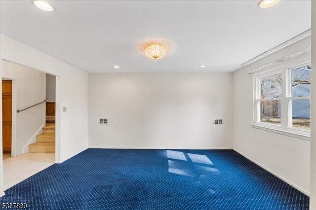 carpeted spare room featuring stairs, baseboards, visible vents, and recessed lighting