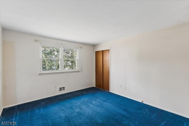 carpeted empty room featuring visible vents