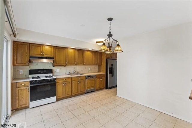 kitchen with light countertops, paneled dishwasher, stainless steel fridge, under cabinet range hood, and white gas range oven