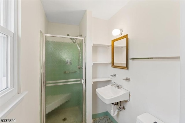 full bath with a sink, a shower stall, and toilet