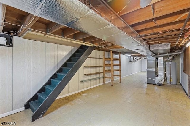 unfinished below grade area with heating unit, stairs, gas water heater, and tile patterned floors