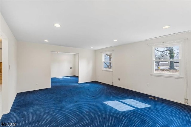 carpeted empty room featuring baseboards, visible vents, and recessed lighting