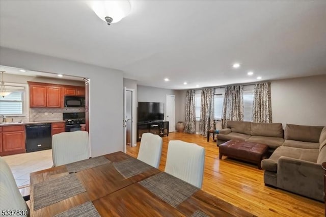 dining space featuring light wood finished floors and recessed lighting