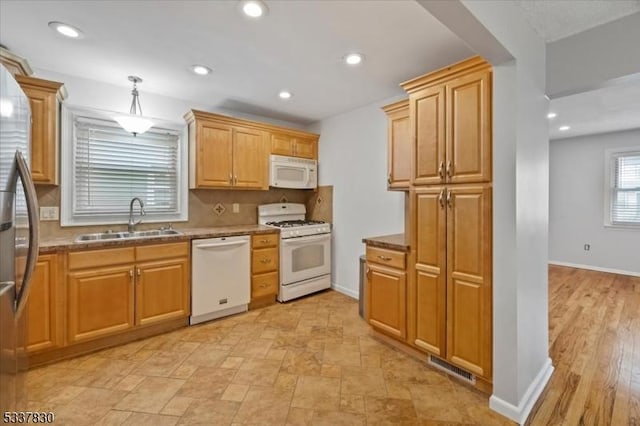 kitchen featuring visible vents, decorative backsplash, recessed lighting, white appliances, and a sink