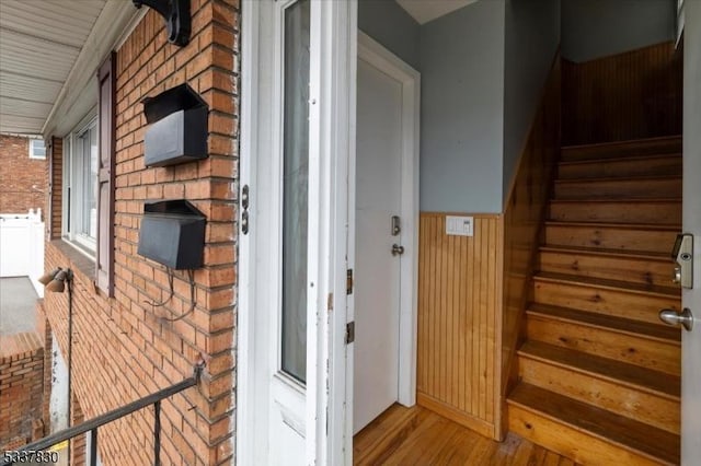 view of exterior entry featuring a porch and brick siding