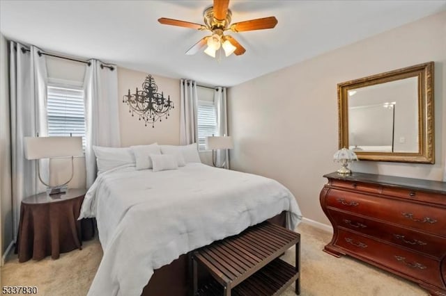 bedroom with a ceiling fan, baseboards, and light carpet