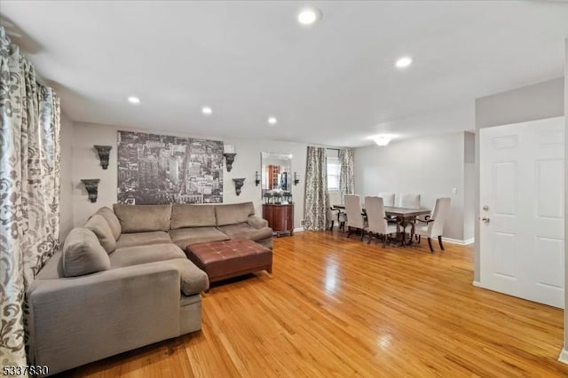 living room featuring light wood-style flooring, recessed lighting, and baseboards