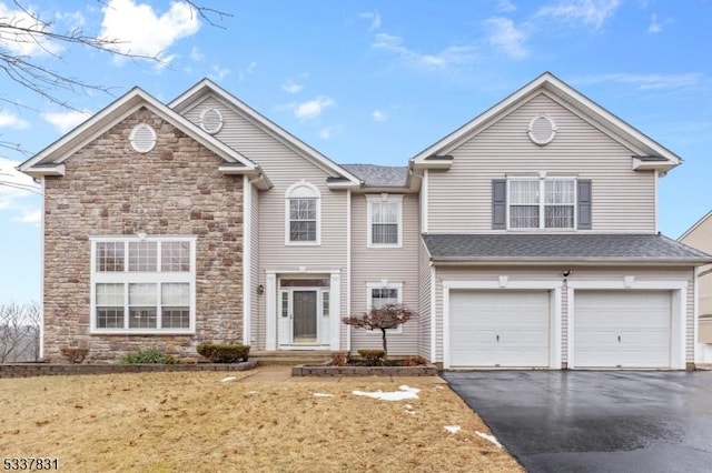 traditional home with stone siding, aphalt driveway, and an attached garage