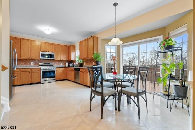 kitchen featuring stainless steel appliances, light countertops, decorative backsplash, brown cabinets, and decorative light fixtures