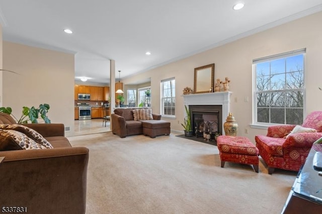 living room featuring light carpet, a fireplace with flush hearth, crown molding, and recessed lighting