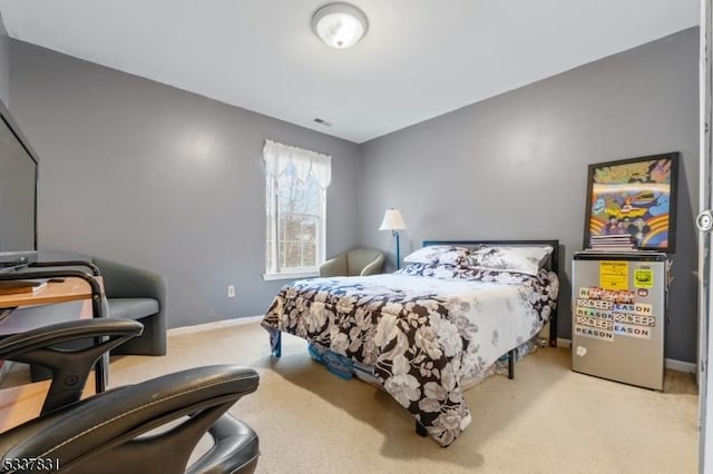 bedroom with light colored carpet and baseboards