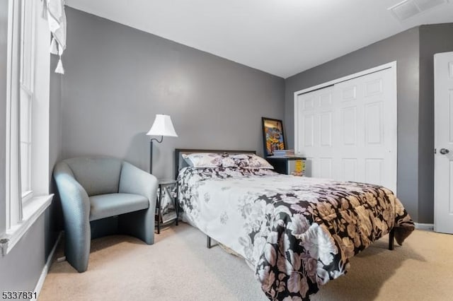 bedroom featuring carpet floors, a closet, visible vents, and baseboards