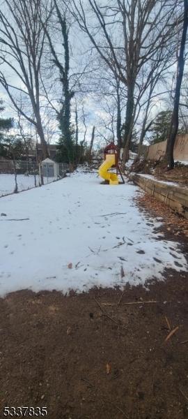 yard covered in snow with a playground