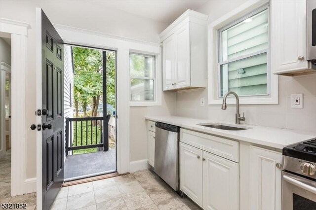 kitchen with white cabinetry, sink, and stainless steel appliances