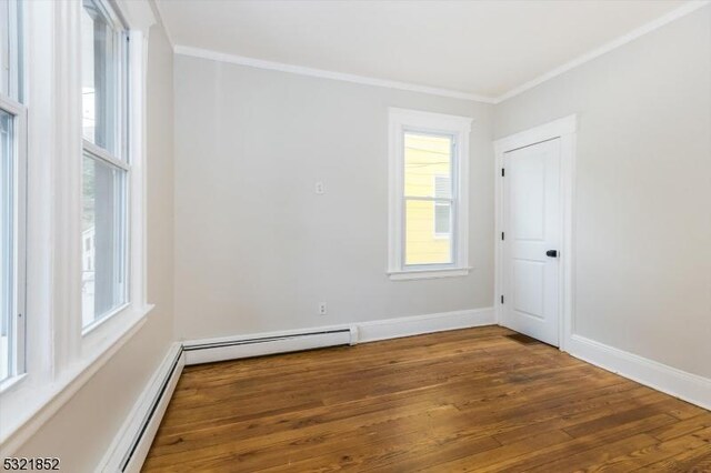 unfurnished room featuring hardwood / wood-style floors, plenty of natural light, ornamental molding, and baseboard heating