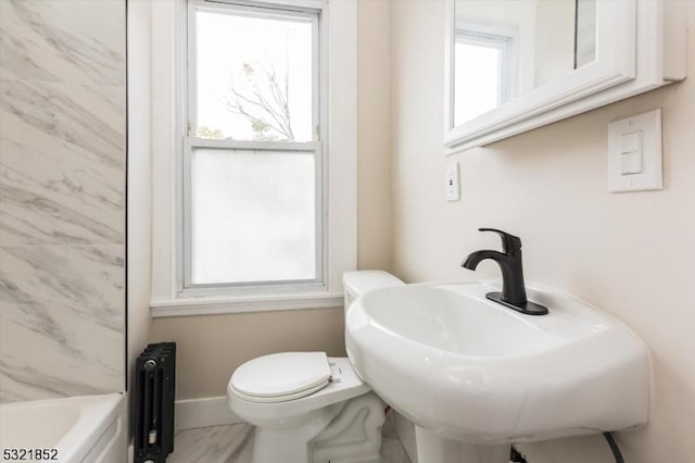 bathroom featuring a tub to relax in, toilet, radiator, and sink