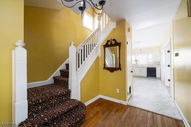 staircase featuring a chandelier and hardwood / wood-style floors