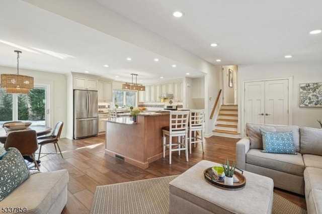 living room featuring stairs, wood finished floors, and recessed lighting