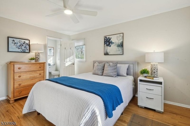 bedroom featuring ensuite bath, wood finished floors, a ceiling fan, and baseboards