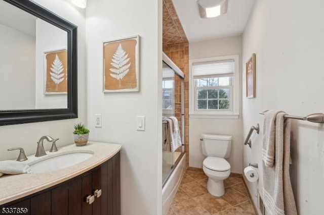 bathroom featuring baseboards, vanity, toilet, and tile patterned floors