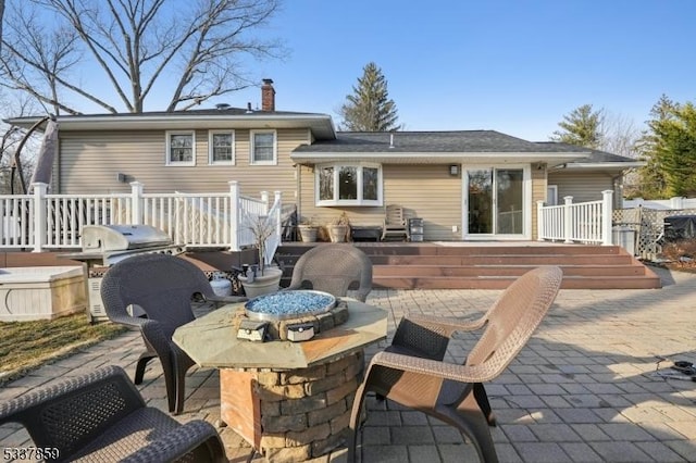 rear view of property with a patio area, a chimney, and a wooden deck