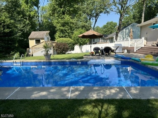 view of pool with a wooden deck, grilling area, fence, and a fenced in pool