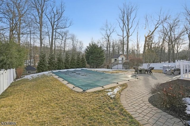 view of swimming pool featuring a yard, a patio area, fence, and a fenced in pool