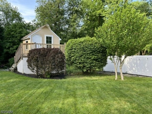 view of yard featuring fence, a deck, and stairs