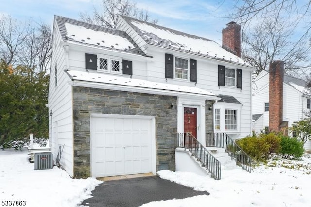 view of front of property featuring central AC unit and a garage