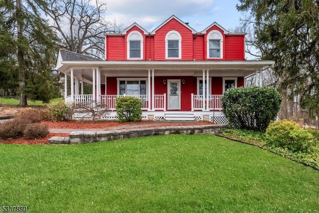 farmhouse featuring covered porch and a front yard