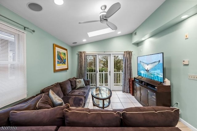 living room featuring lofted ceiling with skylight, ceiling fan, light tile patterned floors, and recessed lighting