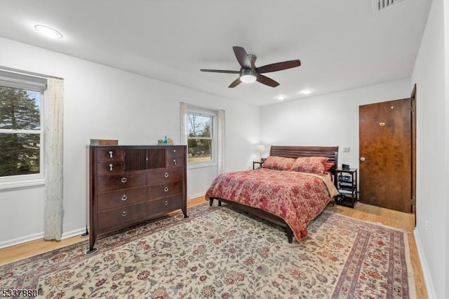 bedroom with recessed lighting, visible vents, ceiling fan, wood finished floors, and baseboards