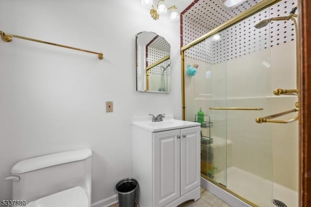 bathroom featuring a stall shower, tile patterned flooring, vanity, and toilet