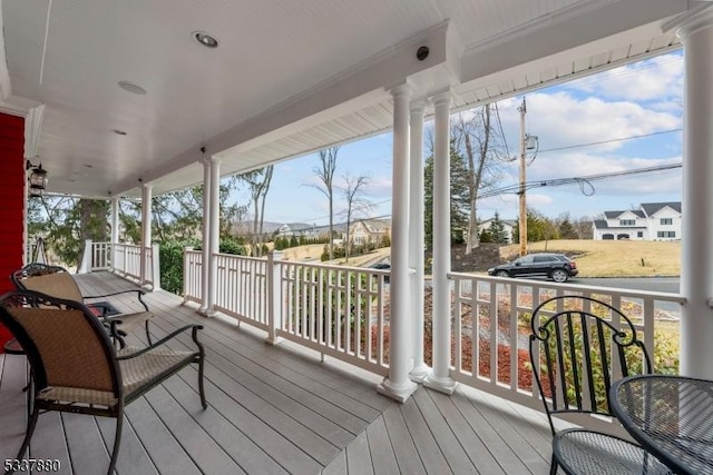 wooden deck with covered porch and a residential view