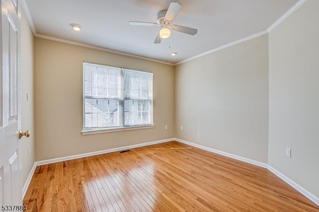 empty room featuring light wood finished floors, baseboards, and ornamental molding