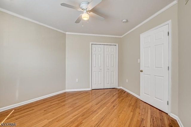 unfurnished bedroom featuring a closet, light wood-type flooring, baseboards, and ornamental molding