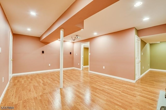 finished below grade area with recessed lighting, light wood-style floors, and baseboards