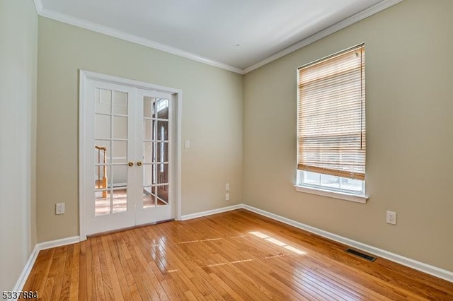 spare room with crown molding, french doors, light wood-type flooring, and baseboards